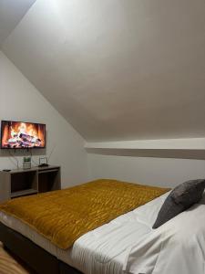 a bedroom with a bed and a flat screen tv at Gîtes by Hôtel Les Reflets Jaunes in Givet