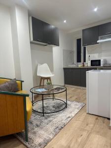 a living room with a table and a kitchen at Gîtes by Hôtel Les Reflets Jaunes in Givet +18 photos