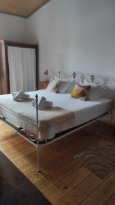a large white bed with a metal frame in a bedroom at Casa da Talha By Viva a Vida - Alojamentos & Hotels in Constância