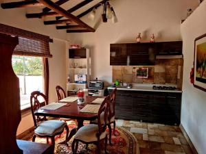 a kitchen with a wooden table and chairs and a kitchen with a counter at La Casona Cucaita in Cucaita