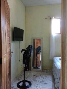 a room with a mirror and a television and a camera at Pousada kurasi alter in Alter do Chao +5 photos