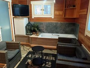 Un baño con bañera, sofá y televisión. en Arctic house, en Rovaniemi 52 fotos más