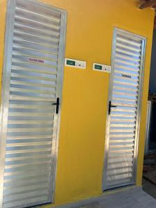 dos puertas están abiertas en una pared amarilla en Rancho Duas Luas Apoio Camping, en Rio das Ostras 13 fotos más