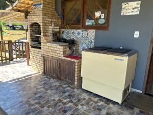 y cocina con horno de ladrillo y fogones. en Rancho Duas Luas Apoio Camping, en Rio das Ostras