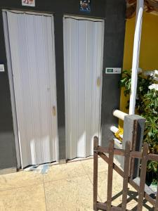 dos puertas blancas en el lateral de un edificio en Rancho Duas Luas Apoio Camping, en Rio das Ostras