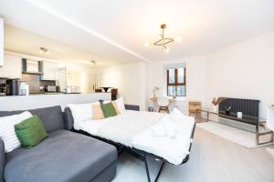 a living room with a couch and a kitchen at Lavish 1 Br Apartment Near Tottenham Stadium in London