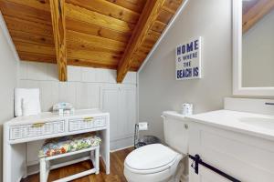 a bathroom with a white toilet and a sink at Coastal Love in Emerald Isle +20 photos