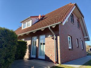 a red brick house with a brown roof at gemütliche Doppelhaushälfte in Burhave in Burhave