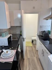 a kitchen with black counter tops and a sink at Great Studio 30min to Central London in London