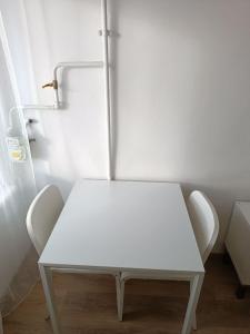 a white table and two chairs in a room at Piekrastes casa in Jūrmala