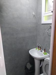 a bathroom with a sink and a toilet at Casa em Boiçucanga in São Sebastião