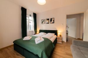 a bedroom with a bed with two towels on it at Domek z trzema sypialniami - Dom Morsa Mielno in Mielno