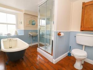 a bathroom with a tub and a toilet and a sink at St Edmunds House in Bedale +25 photos