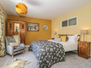 a bedroom with a bed and a chair at St Edmunds House in Bedale