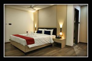 a bedroom with a large bed with a red blanket at Sri Sri Sri Excellency in Khammam