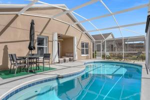een zwembad met een patio met een tafel en stoelen bij 1st Animatronic Dinosaur Villa in Orlando