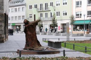 a statue of a tree sitting on a bench at Top Lage in Mainzer Altstadt in Mainz