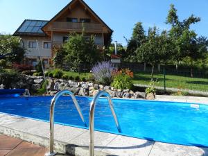 a swimming pool in front of a house at Ferienhaus Zotter in Feldbach