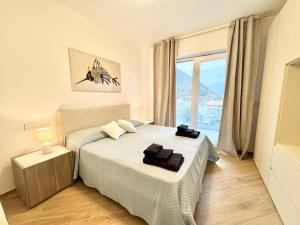 a bedroom with two beds and a large window at Apartment Prestige in Finale Ligure