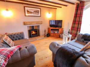 a living room with two couches and a fireplace at Pheasant Cottage in Richmond
