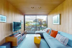 a living room with a blue couch and a television at Rolling Waves Beach House in Sea Ranch