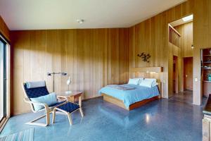 a bedroom with a bed and a table and a chair at Rolling Waves Beach House in Sea Ranch +34 photos