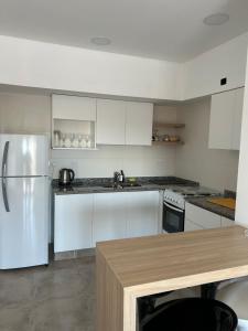 a kitchen with white cabinets and a stainless steel refrigerator at Punto REC in Salta