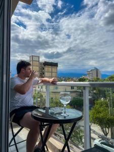 een man op een balkon die een glas wijn drinkt bij Punto REC in Salta