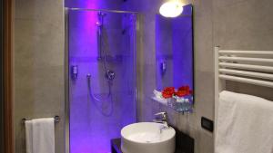 a bathroom with a sink and a shower with purple lighting at Elite Hotel & Spa in Mestre