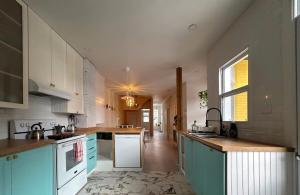 a kitchen with blue and white cabinets and a window at Bright and spacious appartment in Montreal