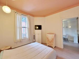 a bedroom with a bed and a desk and a window at Bright and spacious appartment in Montreal