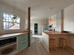 a kitchen with white cabinets and a counter with stools at Bright and spacious appartment in Montreal