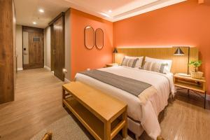 メデジンにあるElegant Space in El Tesoro Recharge in Comfort 308のオレンジ色の壁のベッドルーム1室(大型ベッド1台付)