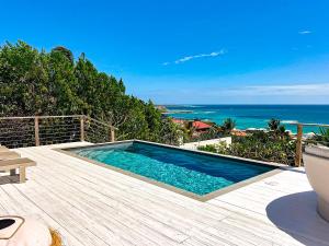 a swimming pool with a view of the ocean at Villa Atao, sublime view of Orient Bay and the islands in Cul de Sac