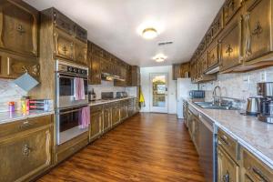 eine große Küche mit Holzschränken und Geräten aus Edelstahl in der Unterkunft Inventor's Cottage in Underwood + 23 Fotos