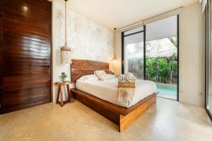 een slaapkamer met een bed en een grote glazen deur bij Jungle Resort Suite with Private Pool near Tulum in Balcheil
