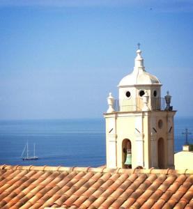 a white clock tower on top of a roof at Hotel Cyrnos in Cargèse