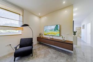 a living room with a chair and a television on a wall at Penthouse apartment Optimum in Korčula