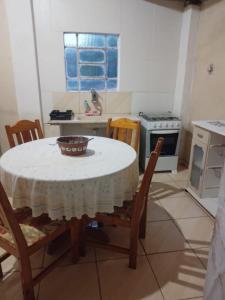 a kitchen with a table with chairs and a stove at Pousada Paraíso Pedacinho Do Céu 2 in Águas de Lindóia