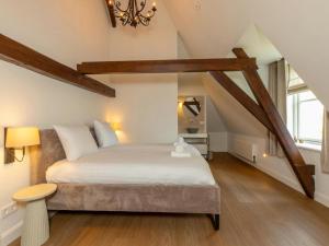 a bedroom with a large bed in a attic at Farmhouse in Zeeland with Windmill Views in Heinkensand