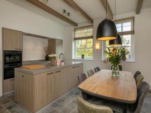a kitchen with a wooden table and a dining room at Farmhouse in Zeeland with Windmill Views in Heinkensand