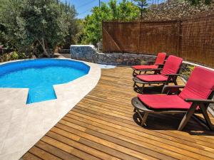 a deck with two chairs and a swimming pool at Malpais de Candelaria Villa with Pool in Bence