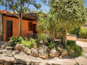 a garden in front of a house with trees and rocks at Malpais de Candelaria Villa with Pool in Bence