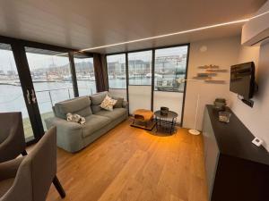 a living room with a couch and a tv at Hausboot Fjord MobyDick in Flensburg mit Dachterrasse in Flensburg
