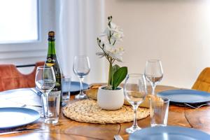 a table with glasses and a bottle of wine at 3 pièces, climatisé, calme, 100m du centre, parking, "Lyriade" in Sarlat-la-Canéda