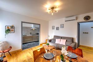 a living room with a couch and a table at 3 pièces, climatisé, calme, 100m du centre, parking, "Lyriade" in Sarlat-la-Canéda +24 photos