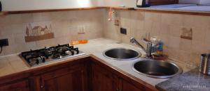 a kitchen counter with a sink and a stove at Comodità a due passi dal lago in Verbania +33 photos
