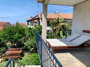 a porch with a white couch on a balcony at Poreč SUNNY Apartment with large balcony by Villa Mihaela in Poreč