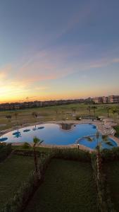 an overhead view of a pool in a park with palm trees at Luxury 3 Bedroom Marrakech Golf Prestigia Saphir in Marrakech