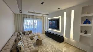 a living room with a couch and a television at Luxury 3 Bedroom Marrakech Golf Prestigia Saphir in Marrakech